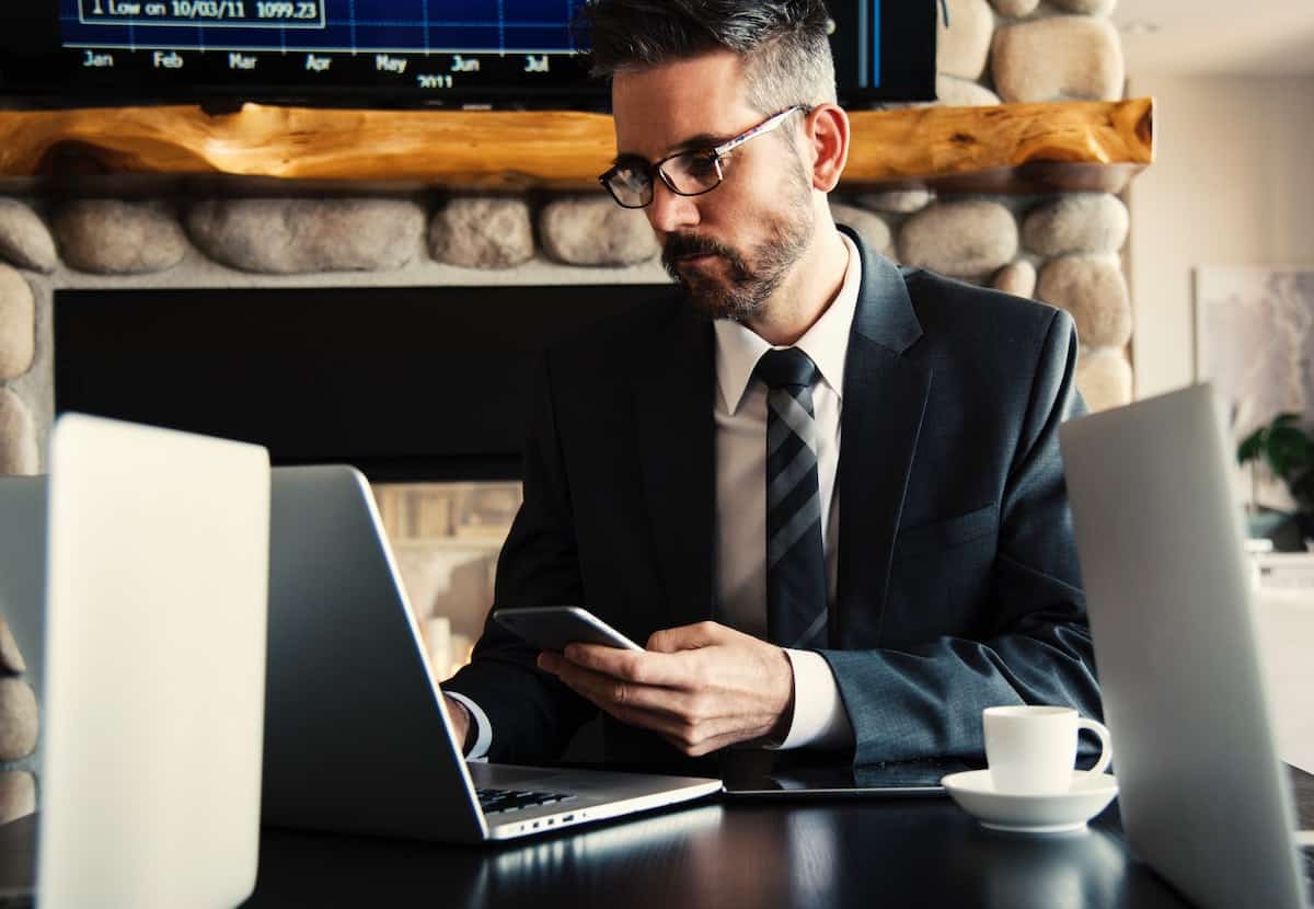 man in black suit holding a phone