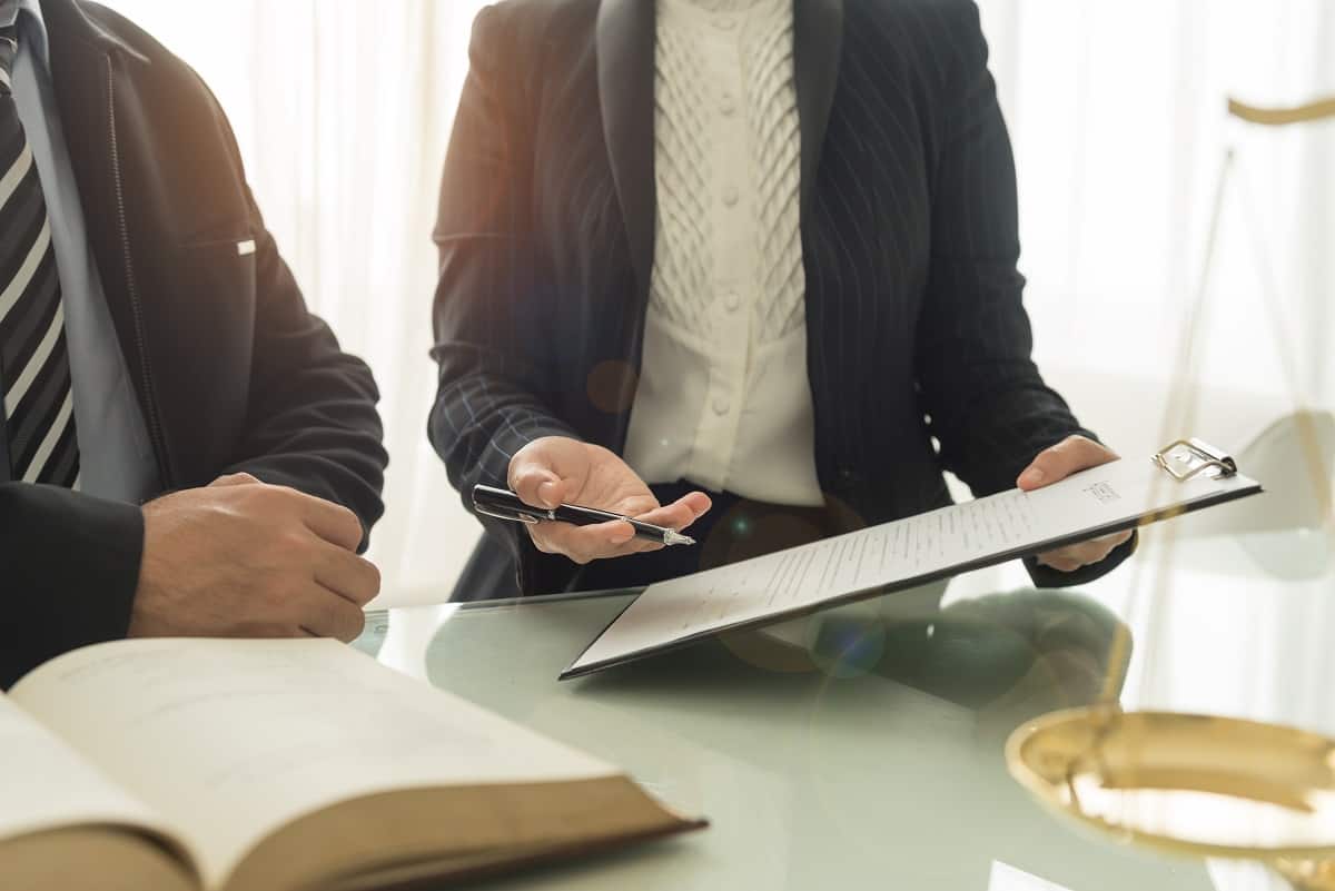 A person discussing with another while holding a clipboard